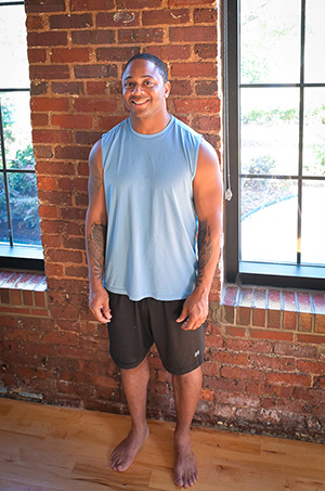 An African American male posing in a relaxed position for a therapeutic bodywork treatment.